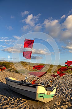Old small fishing boat with many red flags on the beach