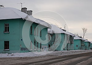 Old small identical houses urban region the city of Ob along the street a gray, overcast winter day