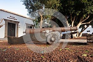 old small iron cannon at the gates of a museum