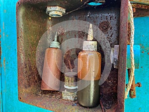 Old small jars are dirty with machine-made brown industrial oil. Oiler for lubrication of parts and internal combustion engine photo