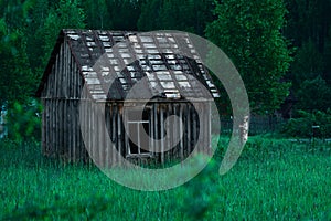 Old small poor village house in high grass at night