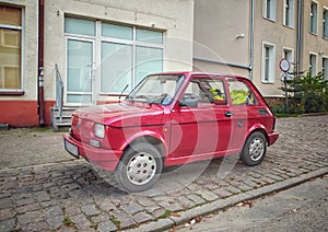 Old small red car Polski Fiat 126p parked