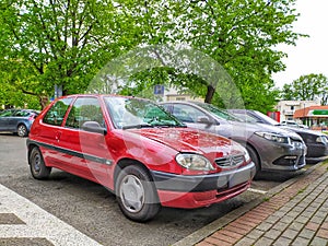 Old small red French compact city car Citroen Saxo parked
