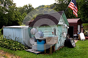 Old small shed with washtubs,tires,american flag..