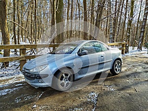 Old small silver grey private car Peugeot 207 cabrio parked