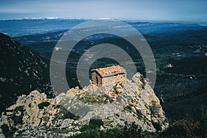 An old small stone house built on top of a rock on the heights