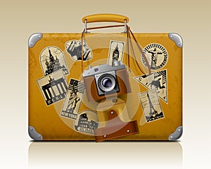 Old small threadbare suitcase with a retro photo camera