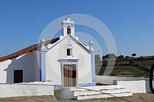 an old small white church with a brown door in front