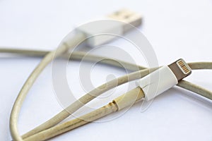 Old Smart Phone Charger Cable broken on white acrylic table background, Close up