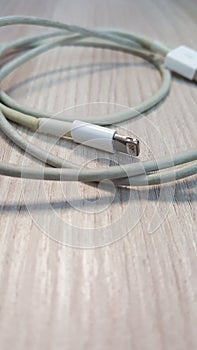 Old smart phone charger wire on laminate floor.