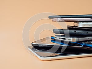 Old smartphones lie on top of each other. Smartphones on an orange background.