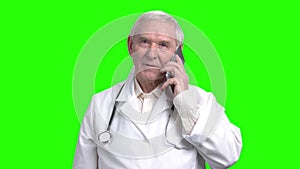 Old smiling doctor talking on the phone.