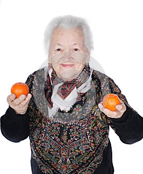 Old smiling woman hoding tangerines in hands