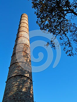 Old smokestack and blue sky and tree