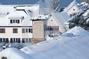 Smoking chimney covered with snow and icicled