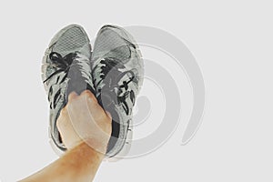 Old sneakers in hand isolated on white background with copy space