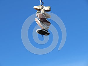 old sneakers hanging on a wire meaning trash photo