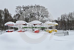 Old snow covered carousel in urban park