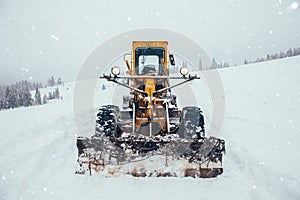 Old snow plow cleaning roads covered in snow up in the mountains