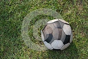 old soccer ball on football grass by top view