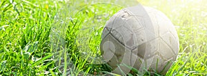 Old soccer ball on the green grass