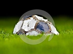 Old soccer ball on grass