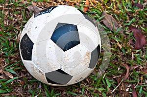 Old soccer ball on green grass