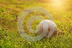 old soccer ball on green grass