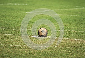 Old soccer ball on green grass