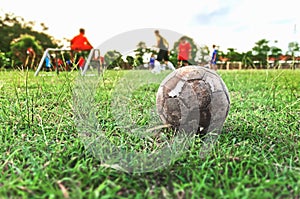 Old soccer ball on green grass field