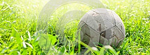 Old soccer ball on the green grass