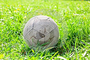 Old soccer ball on the green grass