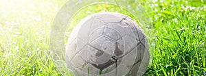 Old soccer ball on the green grass