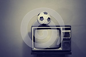 Viejo balón de fútbol sobre el televisión en blanco y negro 