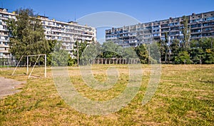 Old soccer field and rusty white soccer goals it the city near the school. Old soccer field overgrown with grass