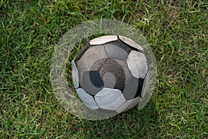 old soccer or football ball on green grass by top view