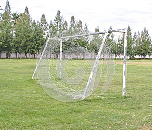 Old soccer goal in field with white cloud