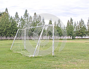 Old soccer goal in field with white cloud
