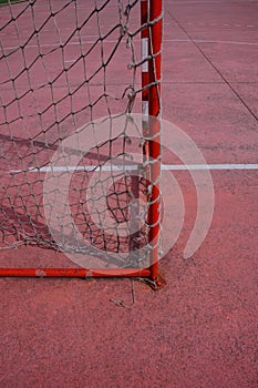 Old soccer goal in the red fiel on the street
