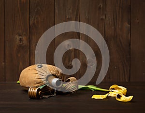 Old soldier`s flask and St. George`s ribbon on wooden background, yellow flower, world war II memorial concept and fallen warrio