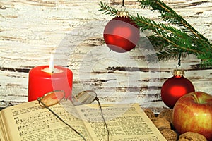 Old songbook, christmas decoration and candle photo