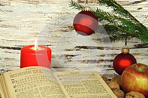 Old songbook, christmas decoration and candle photo