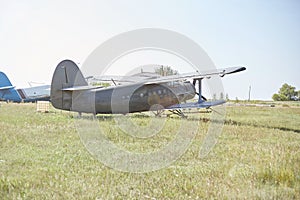 An old Soviet AN 2 aircraft stands at the airfield in the green