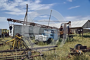 The old Soviet auto and agricultural machinery abandoned in the steppe not far from Sartymbet village, stone mountains