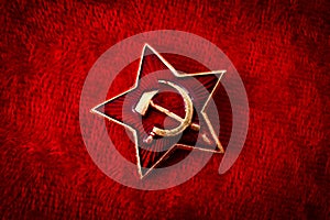 Old Soviet badge with the red star, a sickle and a hammer reminiscent of the cold war era worn by the soldiers of the red army on