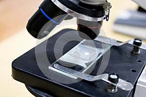 Old Soviet black microscope with a set of eyepieces on a white background.