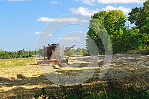 Old soviet combine harvester working in a field