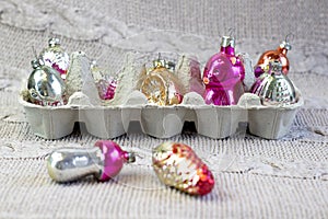 Old soviet decoration in eggbox  glass toy strawberry and pine cone close up on knitted background