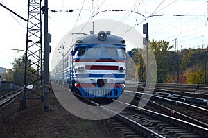 Old soviet electric train with outdated design moving by rail