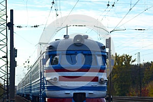 Old soviet electric train with outdated design moving by rail